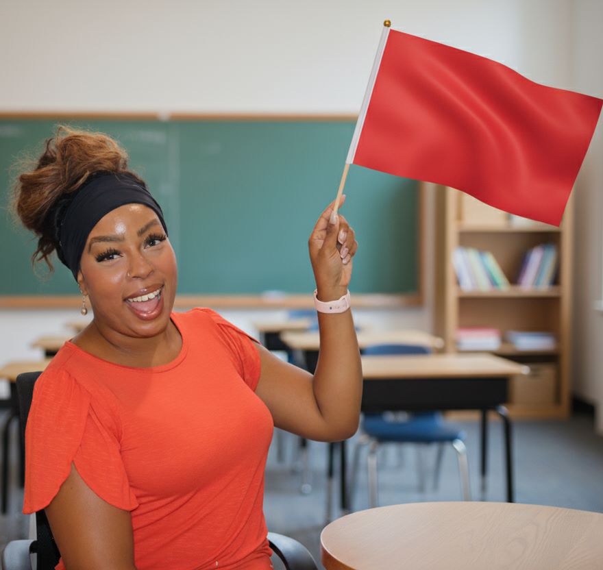 Deonna holding a red flag in a classroom