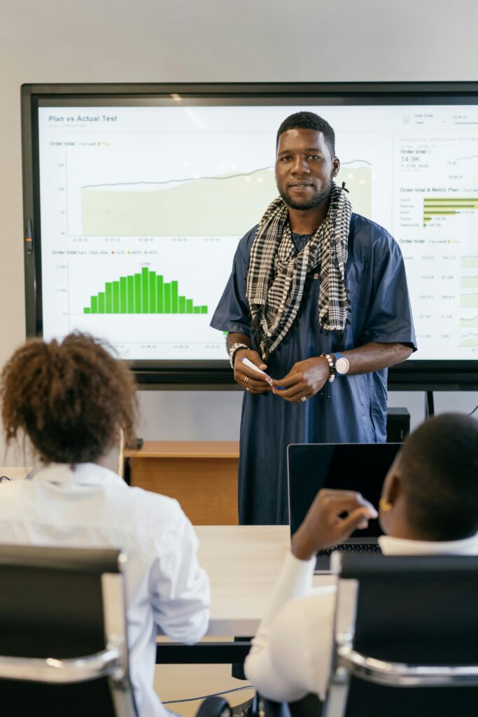 Male teacher in front of a white board in a classroom